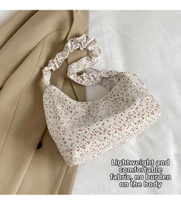 Detailed macro view of floral nylon bag featuring gathered straps and light fabric