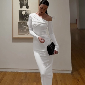 Gros plan détaillé sur la robe blanche à une épaule avec nœud élégant et texture froncée
