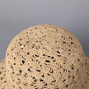 Vue macro détaillée du motif de tissage ajouré sur un chapeau de soleil en raphia