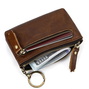 Detail view of brown vintage leather coin purse with double zippers and metal keychain