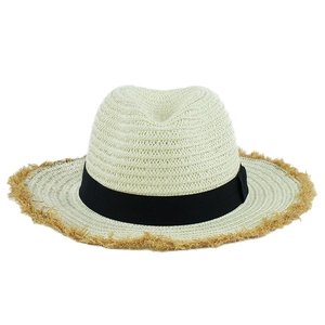 Detailed texture of beige woven straw hat with black ribbon and fringed brim detail