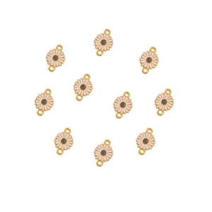 Detailed close-up of ten white enamel daisy flower charms with gold alloy metal borders
