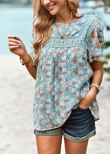 Detail of square neck floral print blouse with lace trim and puff sleeves in beach setting