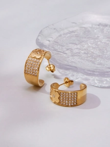 Detailed macro view of gold-plated hoop earrings with micro-pave floral engraving