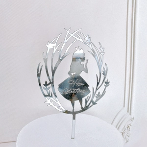 Macro shot of silver mirror acrylic Happy Birthday cake topper with elegant silhouette