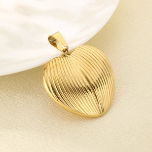 Macro view of gold heart pendant featuring vertical striped texture and polished finish