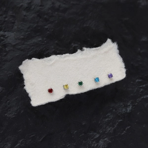 Detailed view of colorful round birthstone earrings set in silver four-prong titanium steel