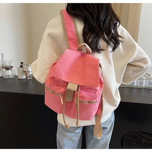 Mochila de lona rosa con bolsillos dobles de cremallera en una cafetería moderna