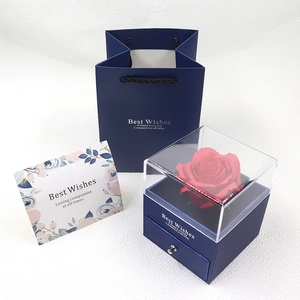 Preserved red rose in acrylic jewelry box with navy blue gift bag and greeting card