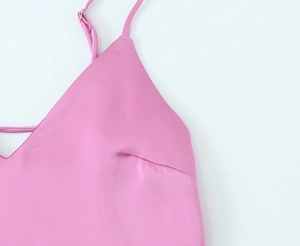 Détails d'une robe midi en satin rose montrant les bretelles réglables et les coutures