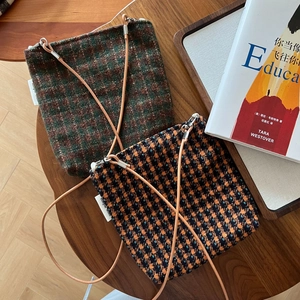 Vintage plaid wool shoulder bags in green brown and orange houndstooth on a wood table