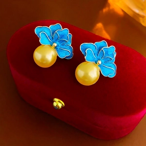 Vintage flower earrings with blue enamel and gold pearls on a red velvet jewelry box