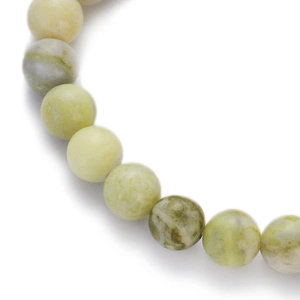 Macro shot of natural stone beads showing polished texture and pale green mineral patterns