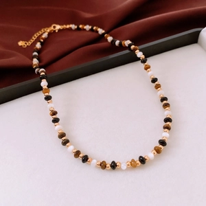 Détail du collier de perles en œil de tigre avec chaîne dorée et fermoir mousqueton