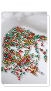 Detailed view of Christmas nail art kit with colorful micro beads and gold metal studs
