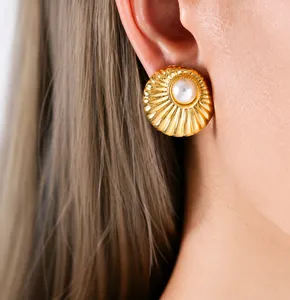 Detail of elegant gold C-shaped earring with radiant shell texture worn by a model