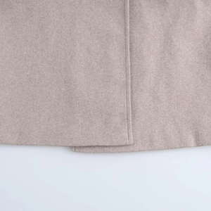 Close-up of beige wool coat hem showing high-quality stitching and texture details