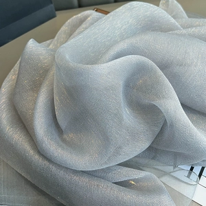 Detail of silver silk shawl fabric with metallic luster and elegant pleated texture