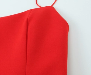 Close-up of neckline stitching and thin straps on a red elastic mini dress for women