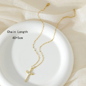 Golden winged cross necklace with crystals on white ceramic plate, length 40+5cm