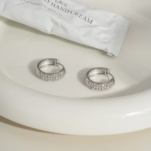Detailed close-up of silver C-shaped hoop earrings with micro-pave cubic zirconia crystals