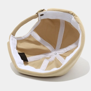 Inside view of a beige cotton skullcap showing stitching and 100% cotton label