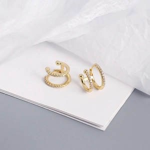 Detailed close-up of gold double-layer huggie earrings with shimmering pavé zircon stones
