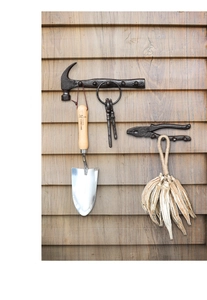 Vintage industrial wall hooks in hammer and pliers shapes on a wooden background