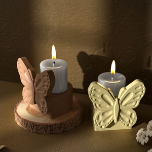 Detailed relief of butterfly candle holders on wood base with warm ambient lighting
