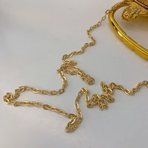 Detailed close-up of a luxury gold metal chain strap featuring a lion head relief buckle