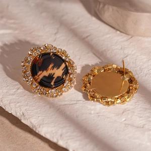Detailed close-up of round leopard print earrings with sparkling crystal-inlaid borders