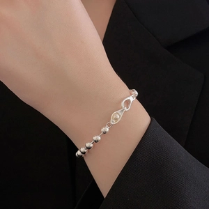 Detail of silver beaded bracelet with teardrop charm and pearl inlay on wrist