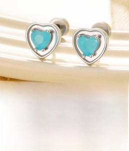 Detailed view of silver titanium steel heart earrings with blue zircon and screw back