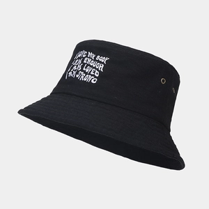 Detailed view of black cotton bucket hat with white letter embroidery and metal eyelets