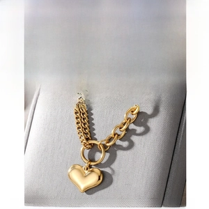 Detail of double-layer golden stainless steel chain with round heart pendant on jewelry box