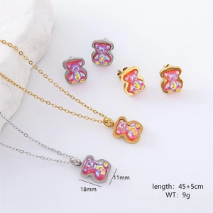 Pink resin bear jewelry set with gold and silver necklaces and earrings on marble