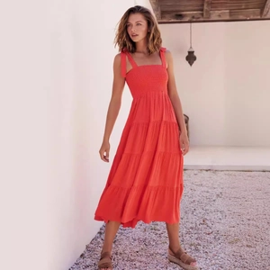 Orange backless midi dress with tie shoulder straps and tiered cake skirt for women