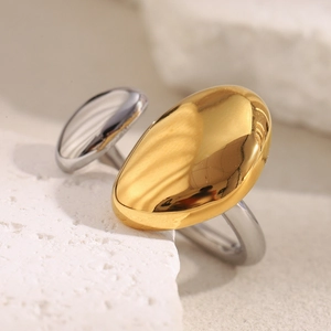Detail of two-tone gold and silver irregular oval rings on a natural white stone base