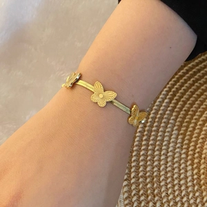 Chic bracelet papillon doré avec une chaîne serpent plate porté au poignet féminin