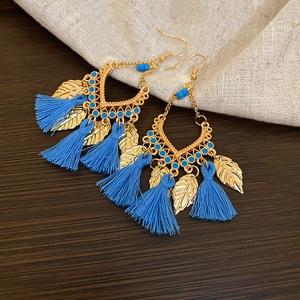 Detailed close-up of Bohemian gold leaf earrings with blue beads and long silk tassels