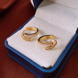 Detail of gold-plated hoop earrings featuring white shell inlay and zircon accents