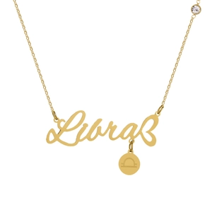 Detail of a golden Libra necklace with engraved lettering and a sparkling crystal charm