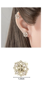 Detailed view of coffee gold fleur-de-lis cartilage stud earrings with micro-inlaid zircons