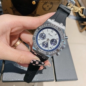 Detailed macro view of white chronograph watch face with diamonds and black rubber strap