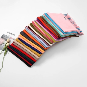 Close-up of multicolored cashmere-like scarves with fringe details in diverse vibrant palettes