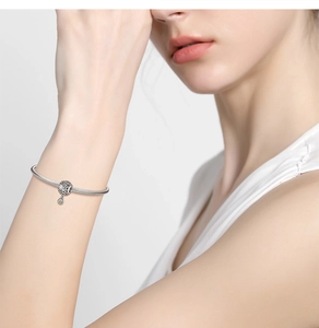 Model wearing a 925 sterling silver snake chain bracelet with hollow charm on wrist