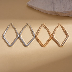 Geometric diamond-shaped hoop earrings set in polished gold and silver metal finishes
