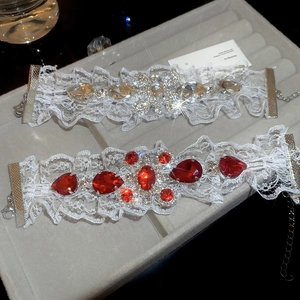 Gros plan de chokers en dentelle blanche avec cristaux rouges et clairs sur velours