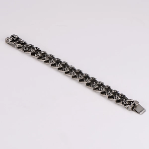 Macro detail of vintage silver stainless steel punk bracelet with double skull links