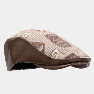 Detail of vintage brown PU leather and striped fabric newsboy cap with retro stamp prints